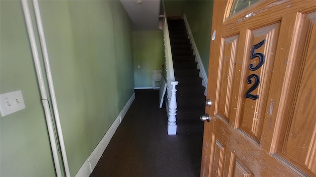 hall featuring baseboards and stairs