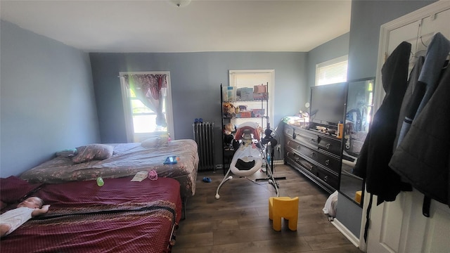 bedroom with radiator heating unit and wood finished floors