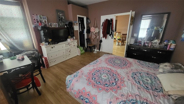 bedroom with wood finished floors and multiple windows