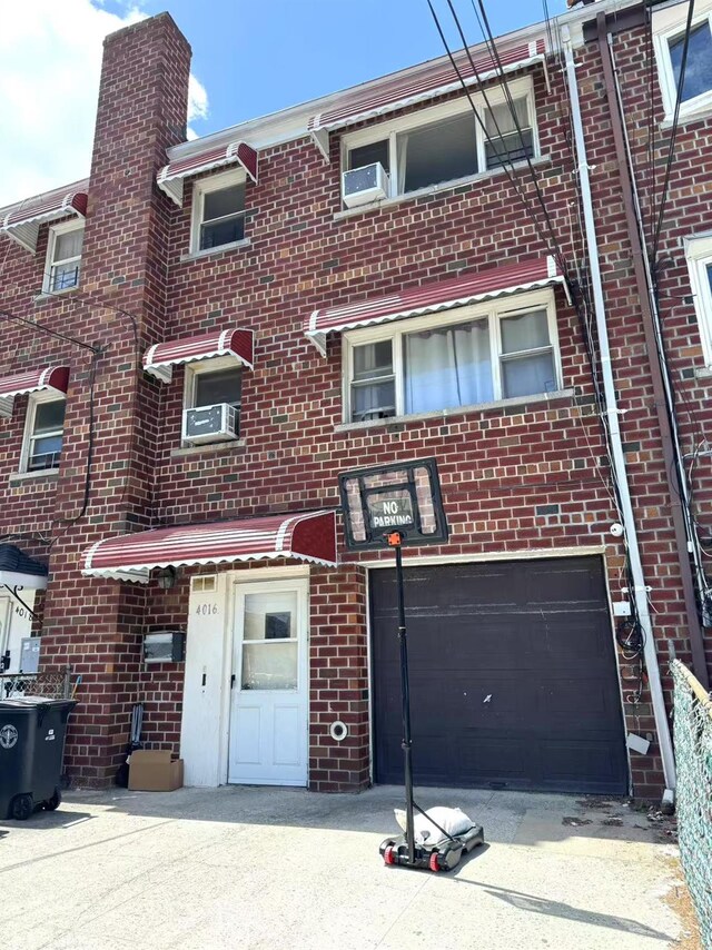 4016 E Tremont Ave, Bronx, NY 10465 - view of property with brick siding, a garage, and cooling unit