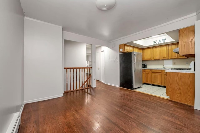 4016 E Tremont Ave, Bronx, NY 10465 - kitchen featuring freestanding refrigerator, light wood-style flooring, a baseboard radiator, light countertops, and baseboards