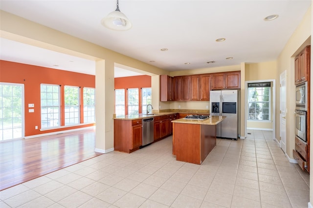 33 Avolet Ct, Mount Sinai, NY 11766 - kitchen with stainless steel appliances, open floor plan, a center island, brown cabinetry, and a sink