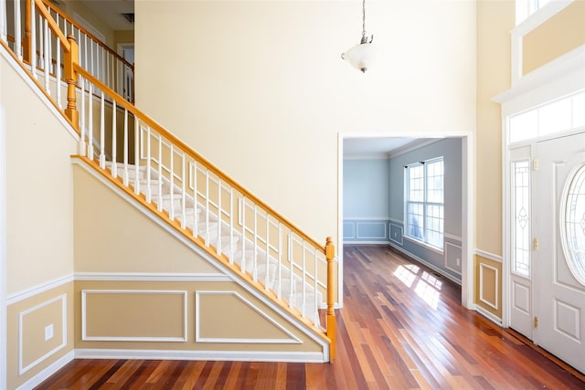 33 Avolet Ct, Mount Sinai, NY 11766 - entryway featuring a decorative wall, stairs, wainscoting, wood finished floors, and a towering ceiling