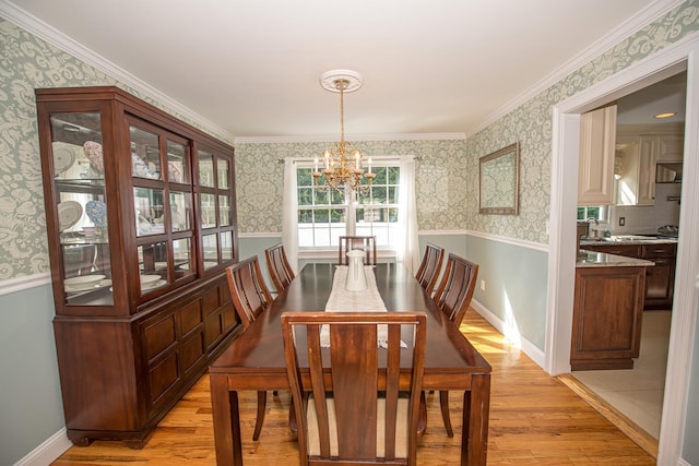 184 Dorothy Rd, West Islip, NY 11795 - dining room with a chandelier, light wood-style floors, wallpapered walls, a wainscoted wall, and crown molding