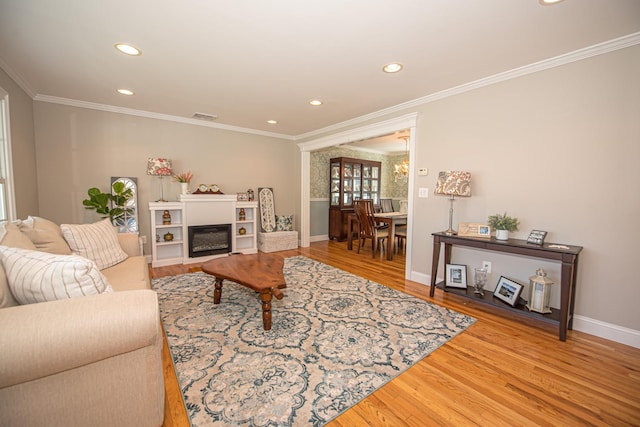 184 Dorothy Rd, West Islip, NY 11795 - living area with wood finished floors, crown molding, recessed lighting, baseboards, and a fireplace