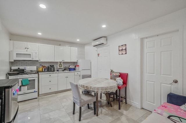 248 44th St, Lindenhurst, NY 11757 - kitchen featuring white appliances, an AC wall unit, a sink, white cabinetry, and decorative backsplash