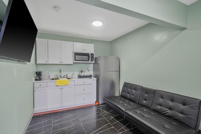 248 44th St, Lindenhurst, NY 11757 - kitchen with stainless steel appliances, a sink, dark marble finish floors, light countertops, and white cabinetry