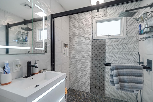 248 44th St, Lindenhurst, NY 11757 - bathroom featuring tile walls, tiled shower, vanity, and plenty of natural light