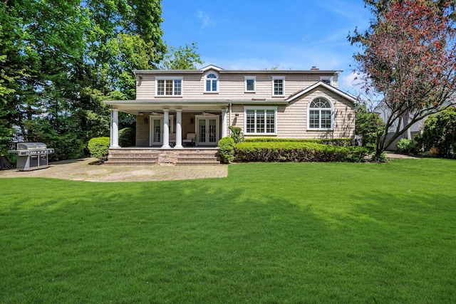 view of front facade featuring french doors and a front lawn