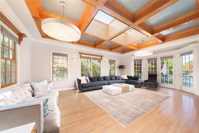 living room with coffered ceiling, wood finished floors, baseboards, crown molding, and french doors