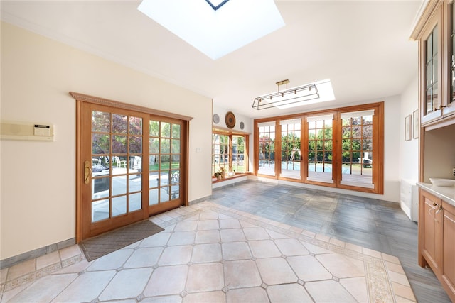 doorway to outside featuring a skylight, baseboards, and french doors