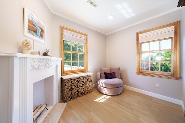 living area featuring crown molding, wood finished floors, and baseboards
