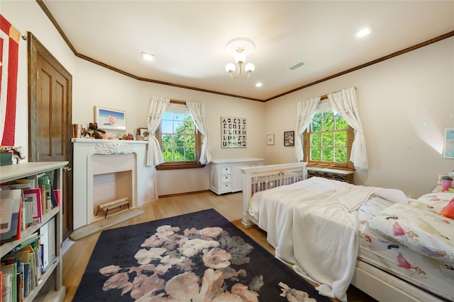 bedroom featuring ornamental molding, light wood finished floors, and baseboards
