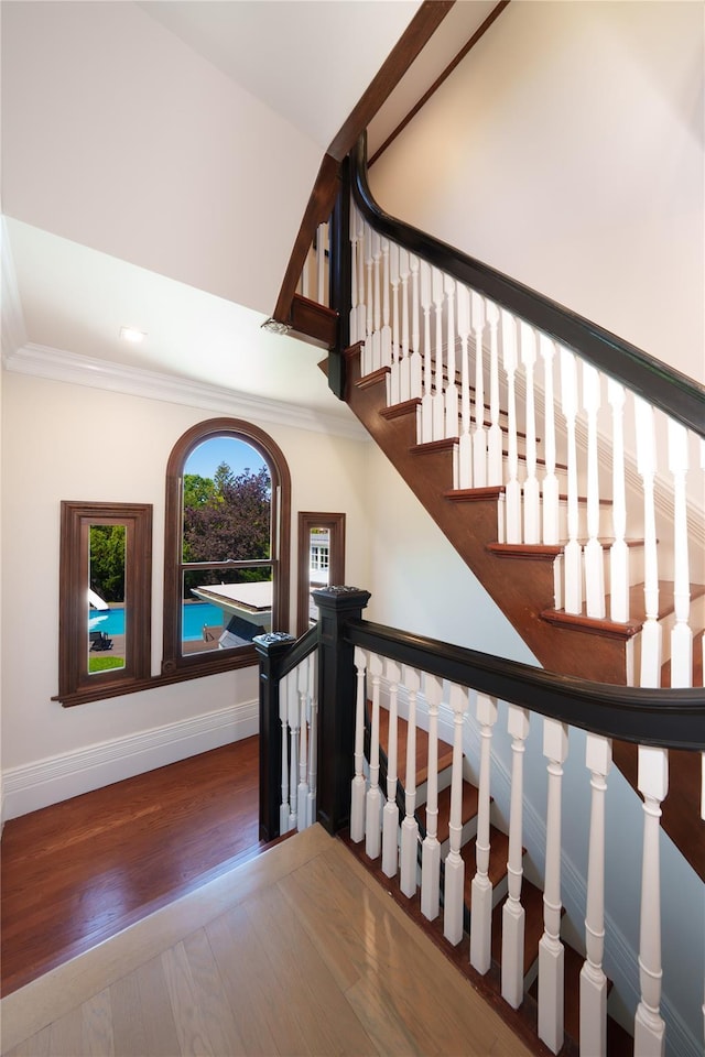 stairs featuring baseboards, wood finished floors, ornamental molding, and recessed lighting