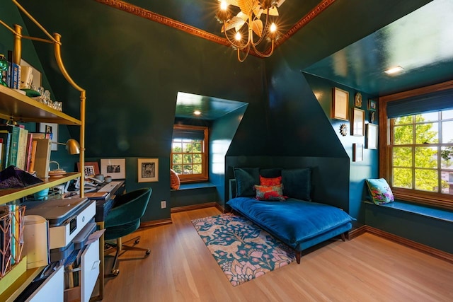 bedroom with wood finished floors, a desk, baseboards, and a chandelier