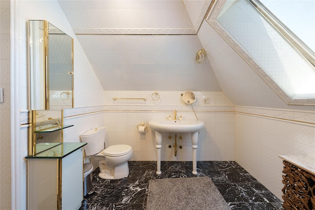 bathroom with vaulted ceiling, toilet, and marble finish flooring
