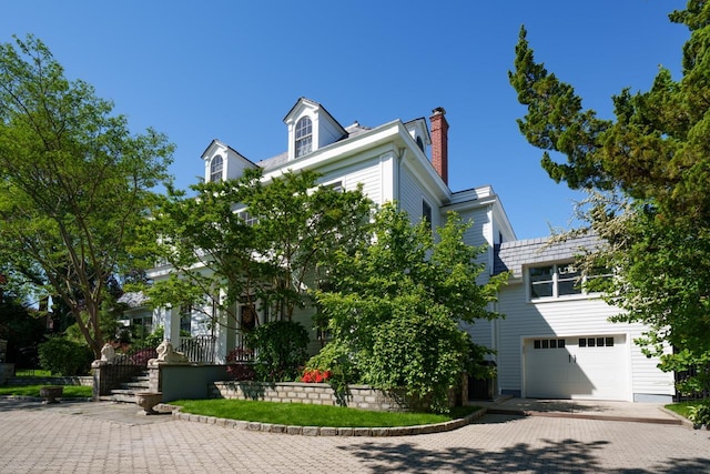 view of front of house with a chimney and a garage