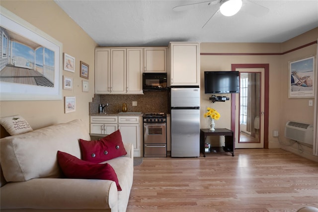 52 Main St Unit 6, Westhampton Beach, NY 11978 - kitchen with appliances with stainless steel finishes, light wood finished floors, ceiling fan, backsplash, and an AC wall unit