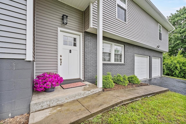 112 Edgehill Dr, Wappingers Falls, NY 12590 - property entrance with brick siding, an attached garage, and asphalt driveway