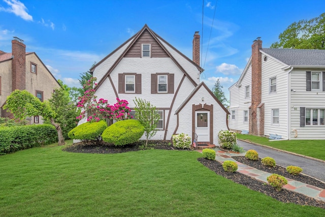 tudor home featuring a front yard