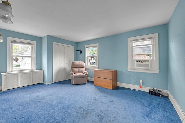 living area featuring radiator heating unit, carpet flooring, plenty of natural light, and baseboards