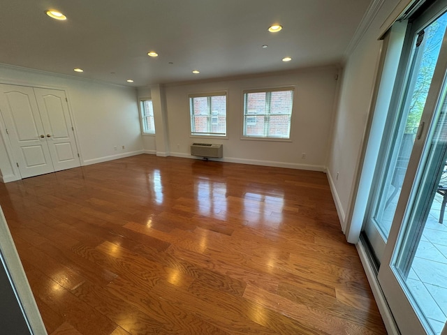 42-23 212th St Unit 3C, Bayside, NY 11361 - spare room featuring crown molding, wood finished floors, recessed lighting, baseboards, and a wall mounted air conditioner