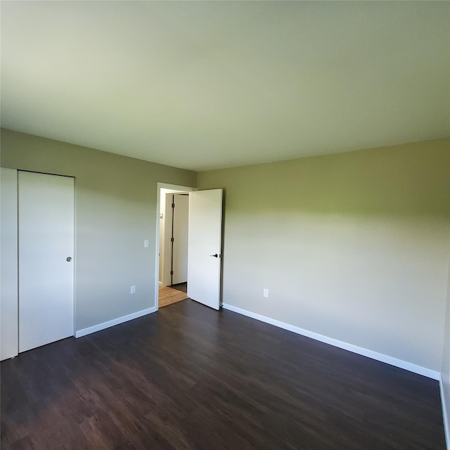 111 Cream St, Poughkeepsie, NY 12601 - unfurnished bedroom with baseboards, dark wood-type flooring, and a closet
