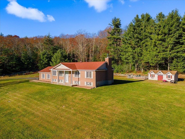 236 Budd Rd, Wurtsboro, NY 12788 - view of front of home with a front yard, an outdoor structure, a forest view, and a chimney
