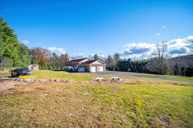 236 Budd Rd, Wurtsboro, NY 12788 - view of grassy yard with asphalt driveway, an attached garage, and a forest view