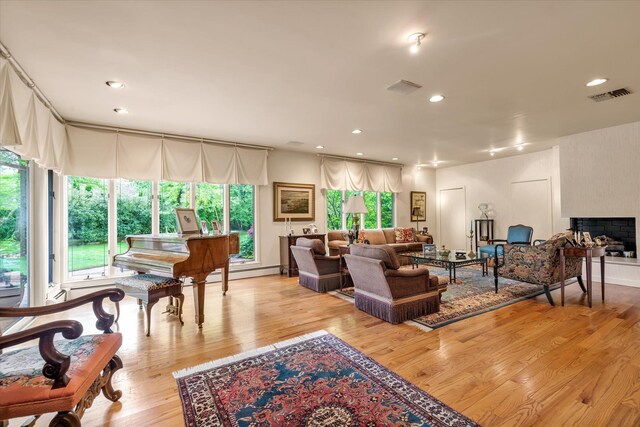 1314 Everit Pl, Hewlett Harbor, NY 11557 - living area featuring a baseboard heating unit, plenty of natural light, light wood finished floors, a large fireplace, and recessed lighting