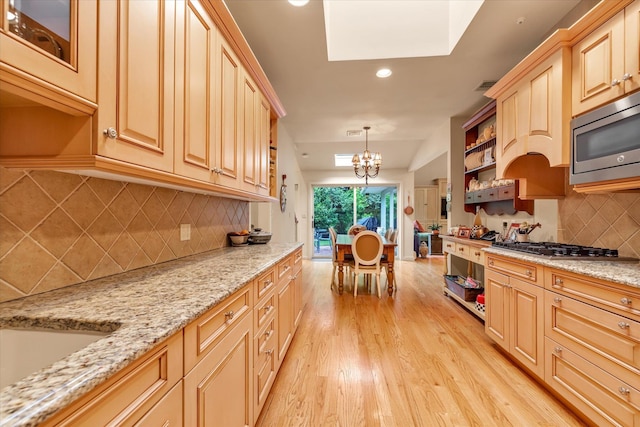 1314 Everit Pl, Hewlett Harbor, NY 11557 - kitchen with stainless steel appliances, open shelves, light wood-style floors, tasteful backsplash, and a chandelier