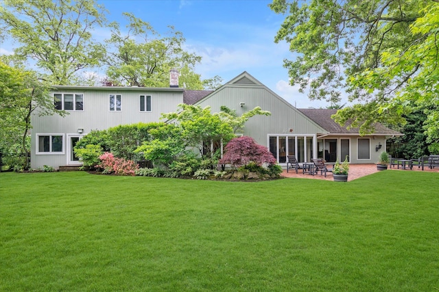 1314 Everit Pl, Hewlett Harbor, NY 11557 - rear view of house with a chimney, a lawn, a patio area, and roof with shingles