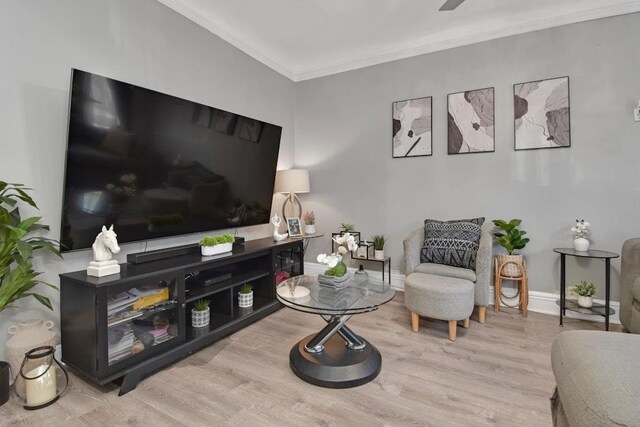 living room with wood finished floors, ornamental molding, and baseboards