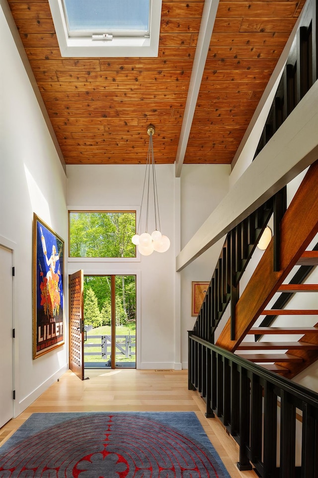 stairs featuring high vaulted ceiling, a chandelier, baseboards, wood finished floors, and beamed ceiling