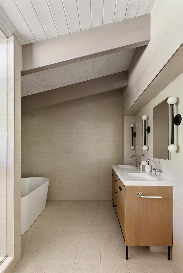 full bathroom with double vanity, a freestanding bath, and beamed ceiling