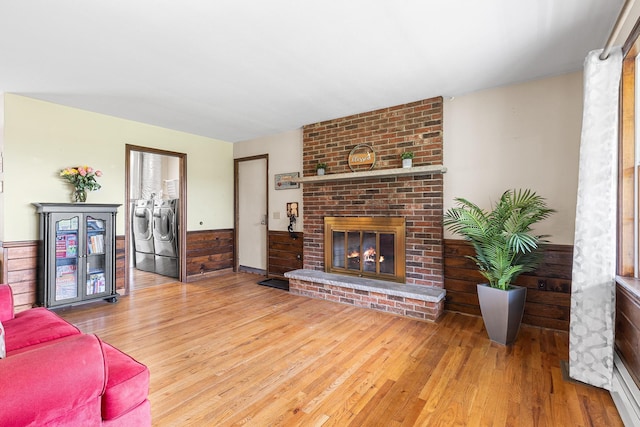 living area with washer and clothes dryer, wood finished floors, and a fireplace