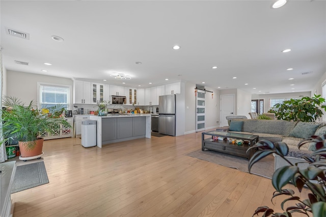3875 S St, Seaford, NY 11783 - living room with a barn door, light wood-style floors, and recessed lighting