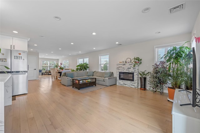 3875 S St, Seaford, NY 11783 - living room with plenty of natural light, a stone fireplace, light wood finished floors, and recessed lighting