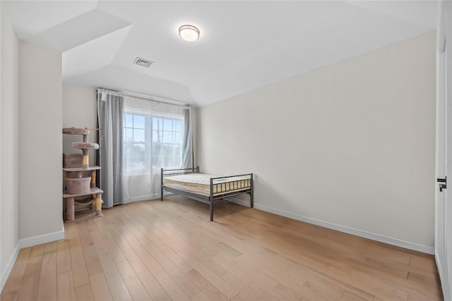 3875 S St, Seaford, NY 11783 - unfurnished bedroom featuring light wood-type flooring, baseboards, and lofted ceiling