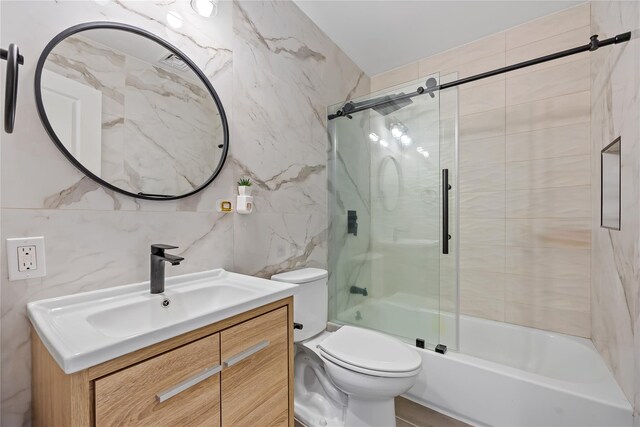 3875 S St, Seaford, NY 11783 - bathroom with tile walls, toilet, vanity, and combined bath / shower with glass door