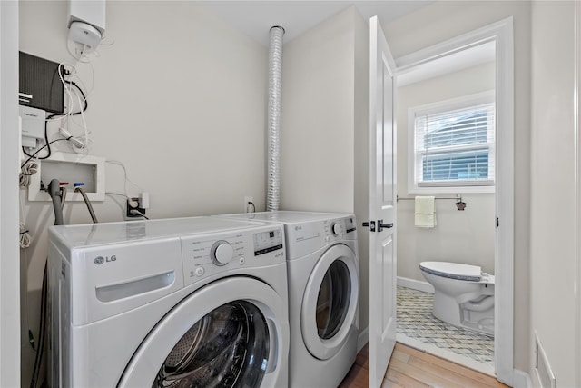 3875 S St, Seaford, NY 11783 - laundry room featuring washer and clothes dryer, light wood-style flooring, and baseboards