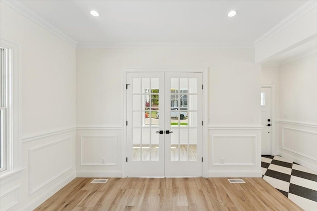 42 Second St, Extension, Glen Cove, NY 11542 - doorway featuring french doors, a decorative wall, crown molding, wainscoting, and light wood-style flooring