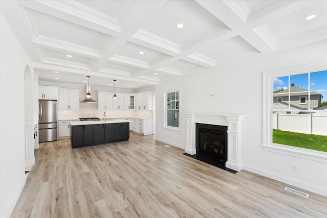 42 Second St, Extension, Glen Cove, NY 11542 - unfurnished living room featuring beam ceiling, light wood-style flooring, coffered ceiling, a sink, and a fireplace with flush hearth