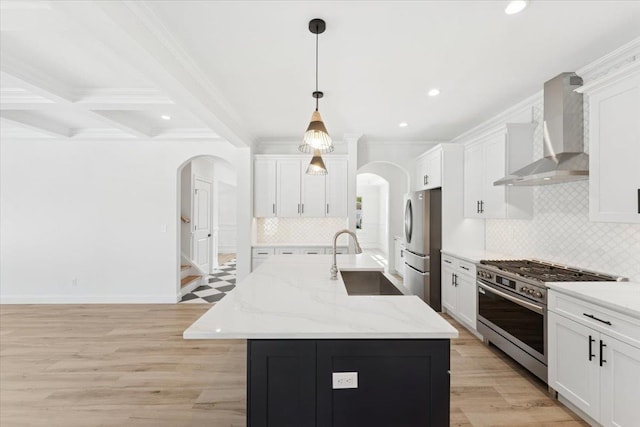 42 Second St, Extension, Glen Cove, NY 11542 - kitchen with appliances with stainless steel finishes, wall chimney range hood, a sink, arched walkways, and backsplash