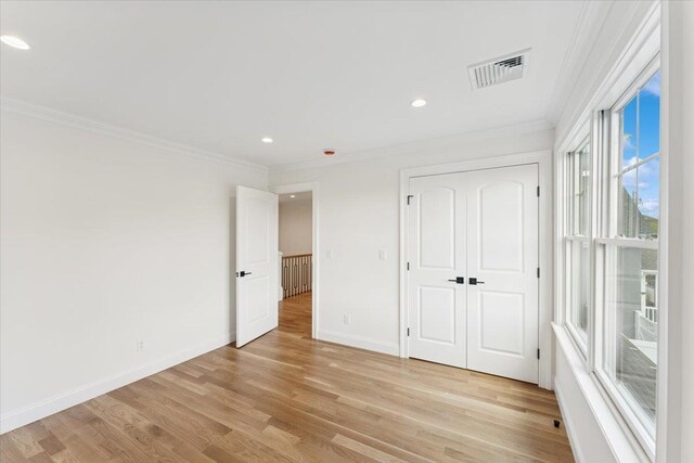 42 Second St, Extension, Glen Cove, NY 11542 - unfurnished bedroom with ornamental molding, light wood finished floors, baseboards, recessed lighting, and a closet
