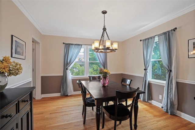 dining space with a chandelier, light wood-style floors, baseboards, and crown molding