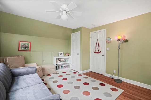 living room with wood finished floors, baseboards, and ceiling fan