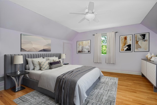bedroom featuring lofted ceiling, light wood-style flooring, baseboards, and ceiling fan