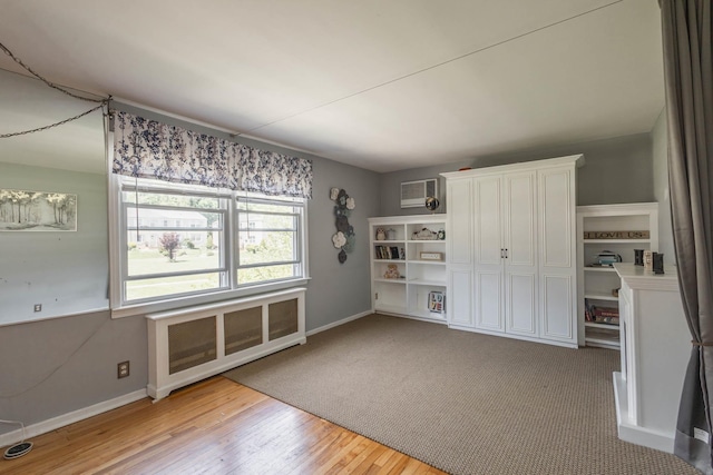 251-12 71st Rd Unit 29B, Bellerose, NY 11426 - interior space with baseboards, wood finished floors, a wall mounted AC, and radiator