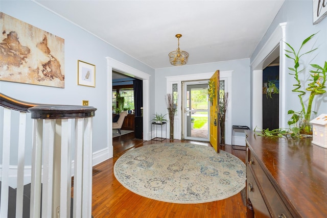 foyer entrance with wood finished floors, baseboards, and a chandelier